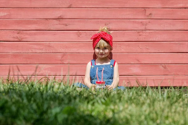 Liten Flicka Hängselbyxa Dricker Mjölk Från Burk Röd Bakgrund Kopia — Stockfoto