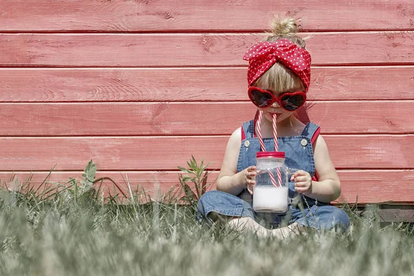 Liittle Meisje Werkbroeken Zonnebril Met Glazen Drinkt Melk Uit Een — Stockfoto