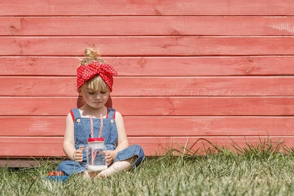 Petite Fille Dungarees Bleues Assise Buvant Lait Dans Jardin Heure — Photo