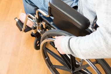 Engelli adam elini tutarak tekerlek bir tekerlekli sandalye detay.