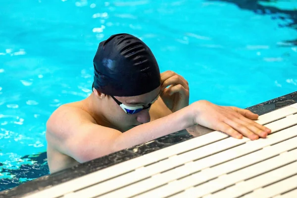 一名青少年运动员改进了室内游泳池中的泳镜 特写镜头 有选择地聚焦 — 图库照片
