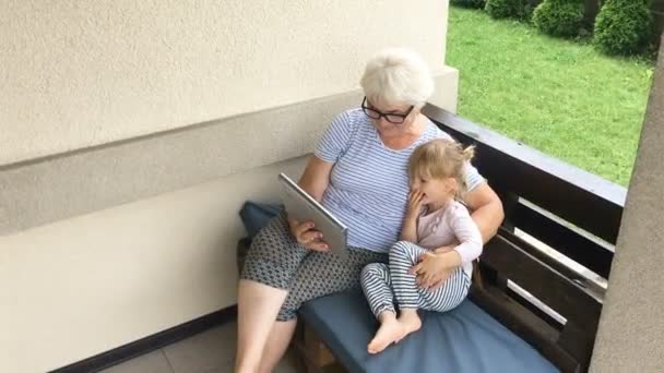 Mormor och barnbarn använder surfplatta. Tid för familjen. — Stockvideo