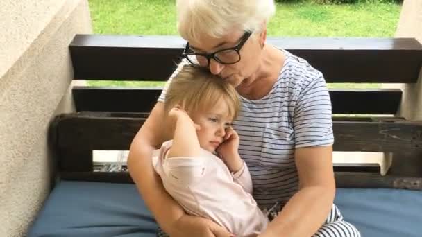 Grand-mère berce sa petite-fille endormie . — Video