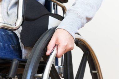 Tekerlekli sandalyede el ele tutuşan engelli kadın detayları. Kapat..