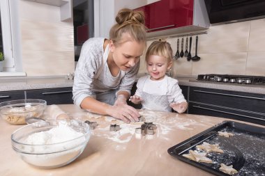 Mutlu bir aile! Küçük bir kızı kurabiye pişirmeye annesi ile mutfakta vakit geçiriyor. Anneler günü.