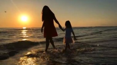 Anne ve çocuk denize yakın yürüme siluet video.