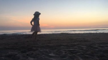 Gün batımında sahilde dans küçük kız.