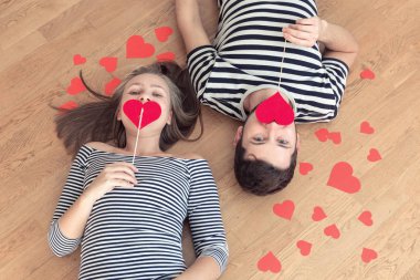 Üstten görünüm genç çift yerde yatarken ve kamera ve gülümseme için arıyorum.