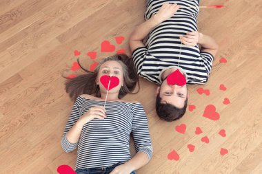 Üstten görünüm genç çift yerde yatarken ve kamera ve gülümseme için arıyorum.