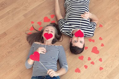 Üstten görünüm genç çift yerde yatarken ve kamera ve gülümseme için arıyorum.