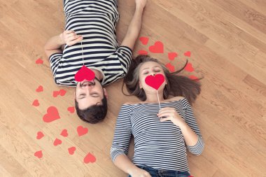 Üstten görünüm genç çift yerde yatarken ve kamera ve gülümseme için arıyorum.