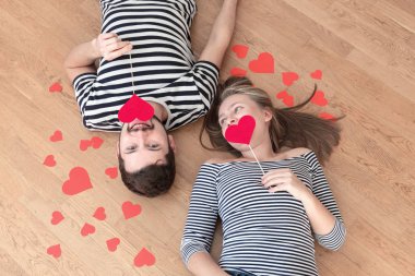 Üstten görünüm genç çift yerde yatarken ve kamera ve gülümseme için arıyorum.