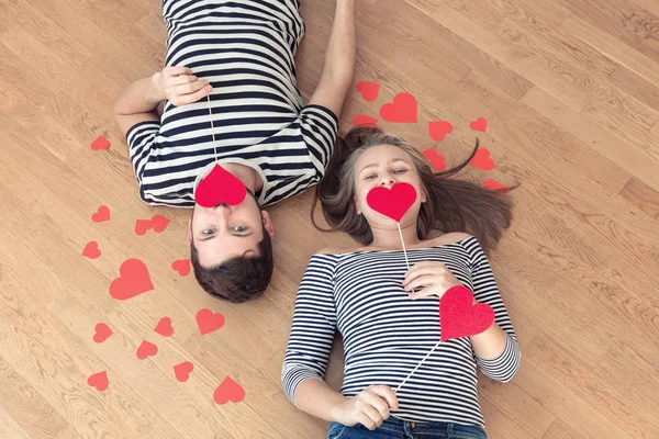 Üstten görünüm genç çift yerde yatarken ve kamera ve gülümseme için arıyorum.