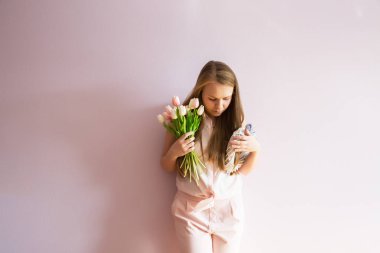 Sarı çözünmüş uzun saçlı, keçe şapka başında, güzel bir genç kızla bahar çiçekleri güneşli bir günde elinde tutar. Kadınlar günü.