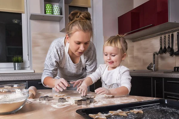 Mutlu bir aile! Küçük bir kızı kurabiye pişirmeye annesi ile mutfakta vakit geçiriyor. Anneler günü.