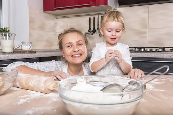 Mutlu bir aile! Küçük bir kızı kurabiye pişirmeye annesi ile mutfakta vakit geçiriyor. Anneler günü.
