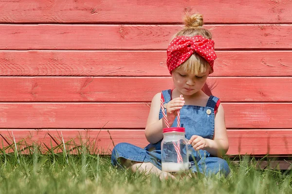 Petite Fille Dungarees Bleues Assise Buvant Lait Dans Jardin Heure — Photo