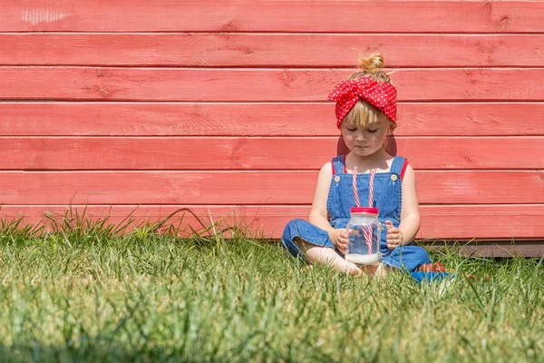 Petite Fille Dungarees Bleues Assise Buvant Lait Dans Jardin Heure — Photo