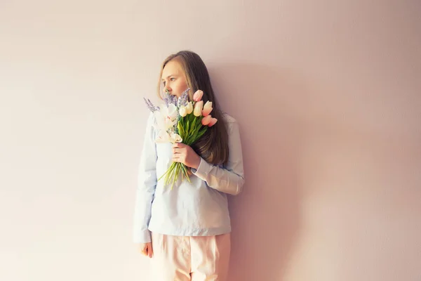 溶存長い金髪 彼女の頭の上にフェルト帽子の美しい少女は 彼女の手で晴れた日に春の花を保持します 女性の日 — ストック写真