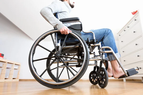 Handicapped man in wheelchair at home.