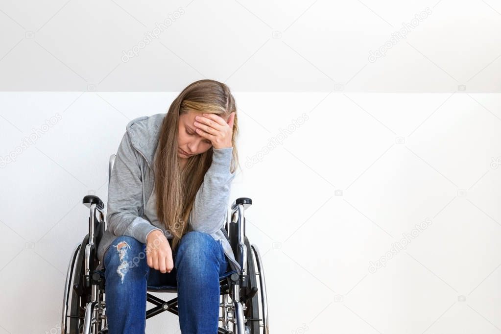 Depressed young woman on wheelchair. Hard invalid concept.