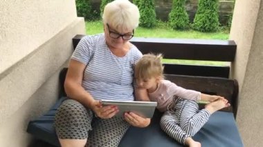 Büyükanne ve torunu kullanarak tablet ve eğlenin