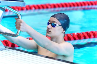 Genç bir atlet bir başlangıç platformu tutuyor.