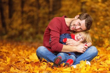 Baba ve kız sarılmak ve sonbahar parkta gülmek.