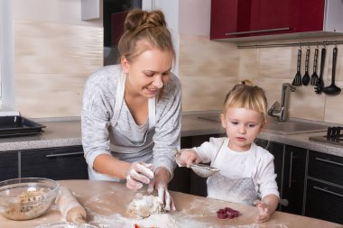 Mutlu bir aile! Küçük bir kızı kurabiye pişirmeye annesi ile mutfakta vakit geçiriyor. Anneler günü.