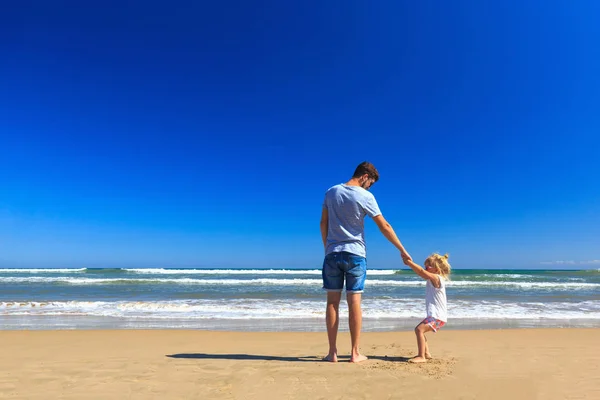 Pai e filha se divertem na praia . — Fotografia de Stock