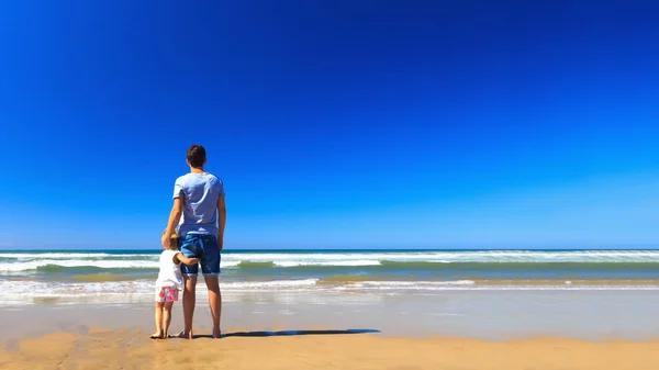 Otec a dcera se bavte na pobřeží. — Stock fotografie