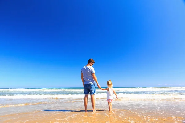Otec a dcera se bavte na pobřeží. — Stock fotografie