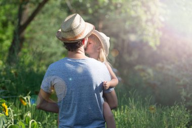 Babası kızını kollarını tutar. Kırsal gezisi.
