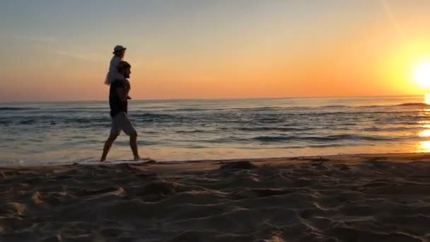 Padre e hija caminando por la playa al amanecer . — Vídeos de Stock