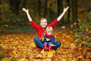 Mutlu sonbaharlar. Bir anne ve kızı oynuyor ve gülüyorlar. 