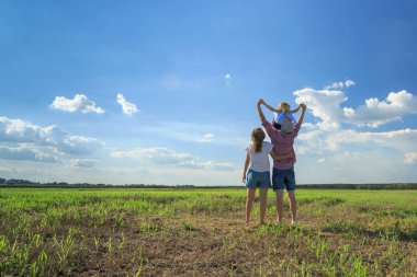 Anne ve kızı buğday tarlasında güneşe bakıyorlar. Geri vi