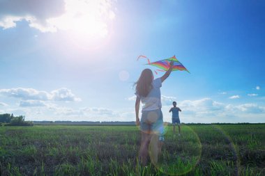 Aile tarlada uçurtma uçuruyor.