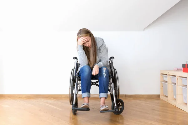 Mujer joven desesperada en silla de ruedas. Concepto inválido duro . — Foto de Stock