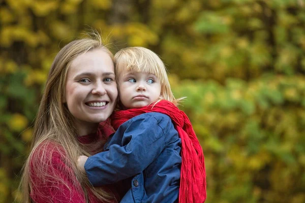 Maman étreint sa fille dans un parc d'automne . — Photo