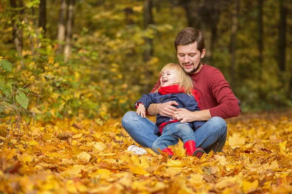 Padre e hija se abrazan y ríen en el parque de otoño . —  Fotos de Stock