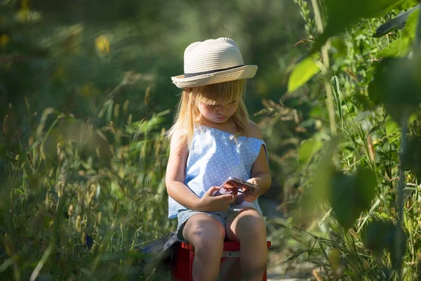 Petite fille utilise un téléphone portable sur le terrain . — Photo