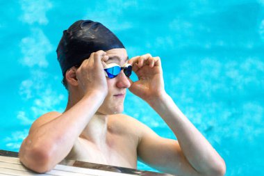 Genç bir atlet kapalı havuzda yüzme gözlüklerini geliştirir. C