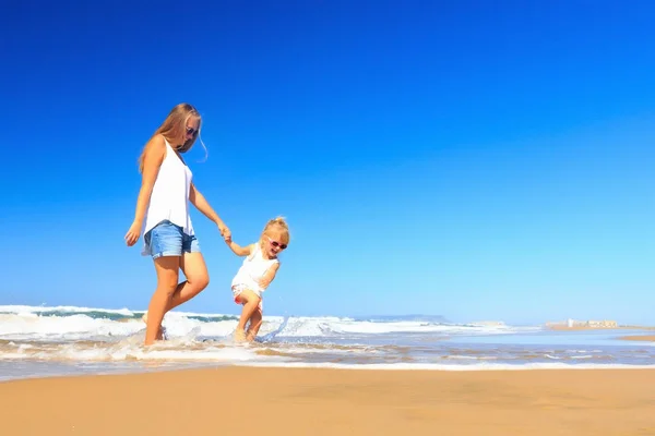 Šťastná matka a dcera tráví dovolenou na pobřeží. — Stock fotografie