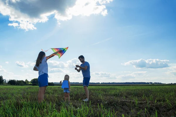 Щаслива сім'я. Мама тато і дочка дивляться на сонце в пшениці — стокове фото