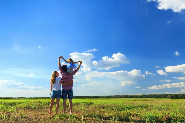 Мама тато і дочка дивляться на сонце на пшеничному полі. Назад Ві — стокове фото