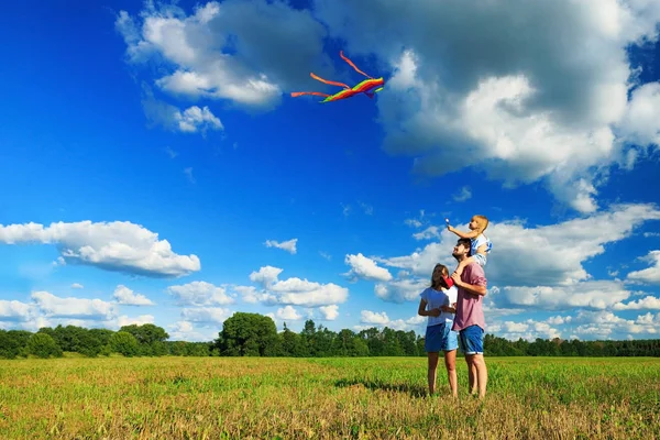 Anne, baba ve kızı tarlada uçurtma uçuruyorlar. Fron — Stok fotoğraf