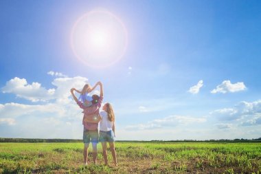 Anne ve kızı buğday tarlasında güneşe bakıyorlar. Geri vi