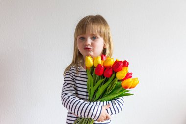 Küçük kız lale çiçek bukettutar. 