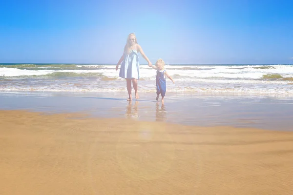 Máma a dcera se procházejí po pláži. Přední pohled, kopírovat spac — Stock fotografie