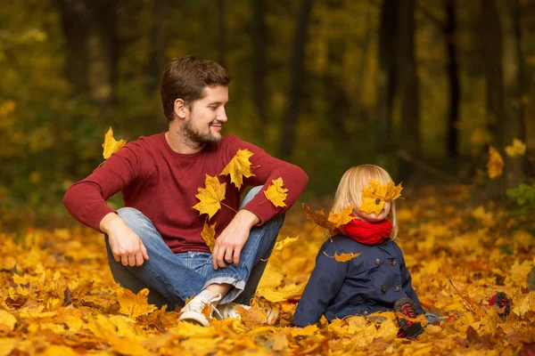 Baba ve kızı bir sonbahar parkında oturup gülüyorlar.. — Stok fotoğraf